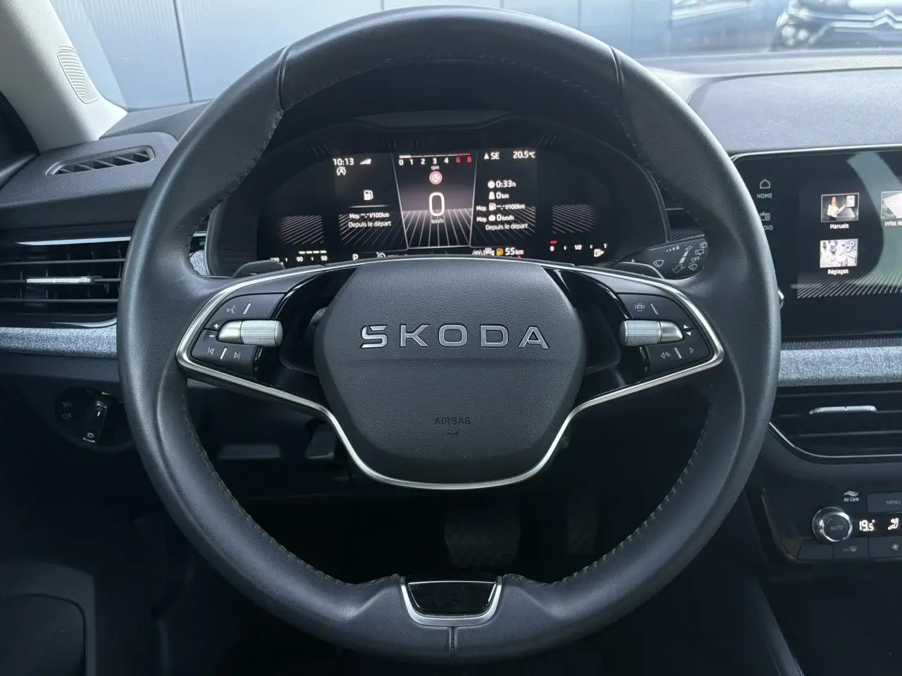 Vue frontale du volant en cuir noir avec logo SKODA, tableau de bord digital et écran tactile du Skoda Scala TSI 116 DSG7.