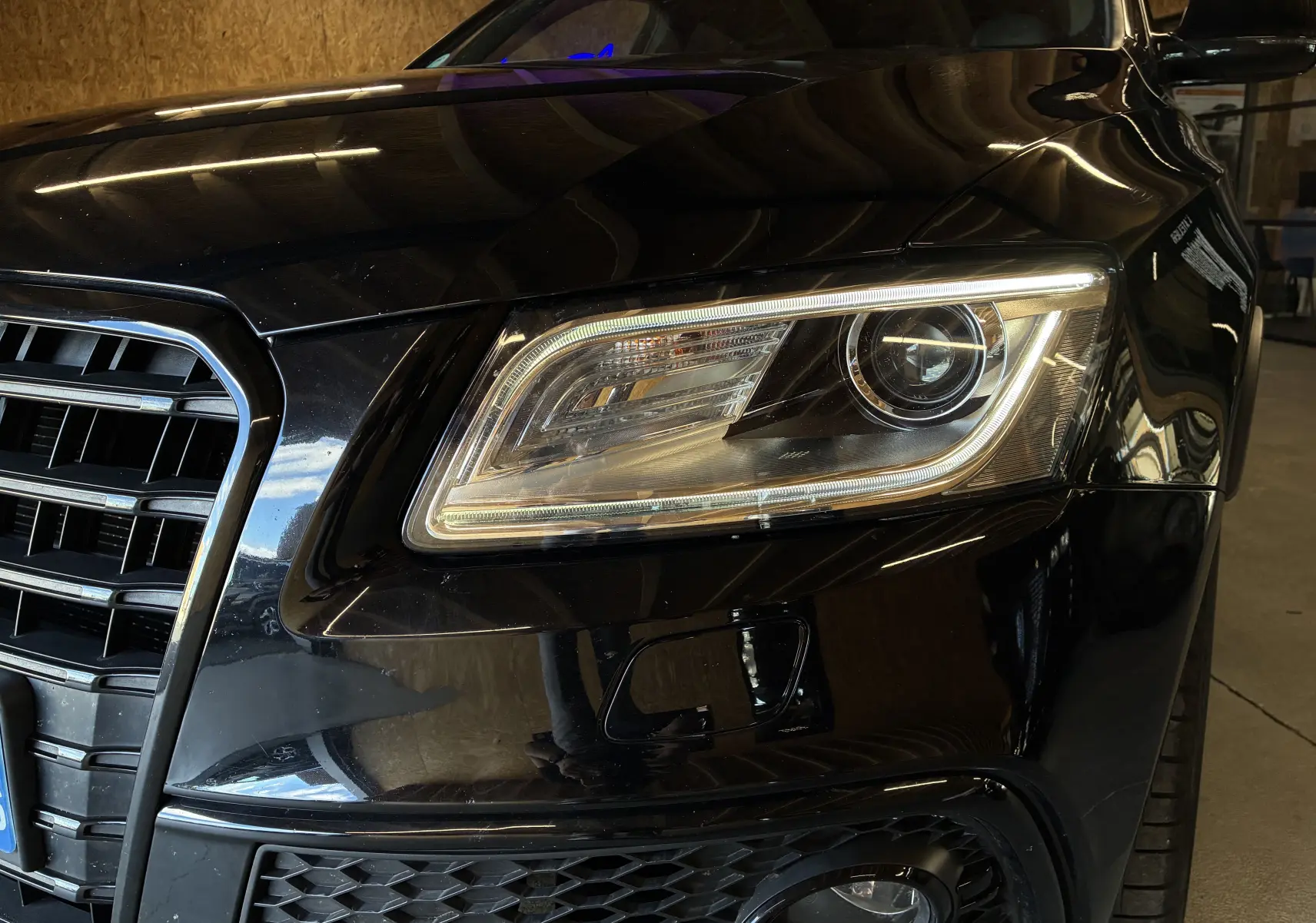 Gros plan sur le phare avant droit noir brillant de l’Audi SQ5 2016 avec calandre et antibrouillard visibles.