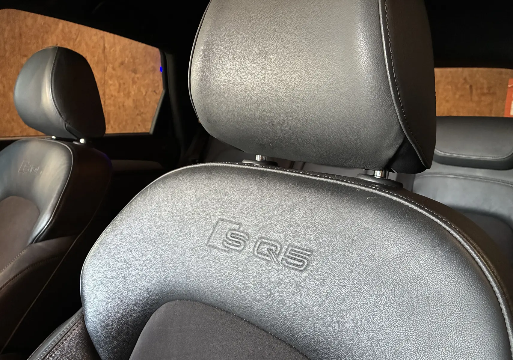Gros plan sur le siège avant en cuir noir embossé du logo SQ5 dans l’habitacle de l’Audi SQ5.