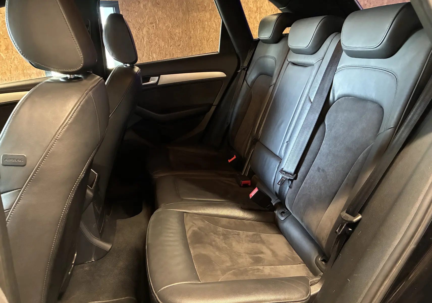 Vue latérale intérieure des sièges arrière en cuir noir de l'Audi SQ5 2016 avec ceintures de sécurité visibles.