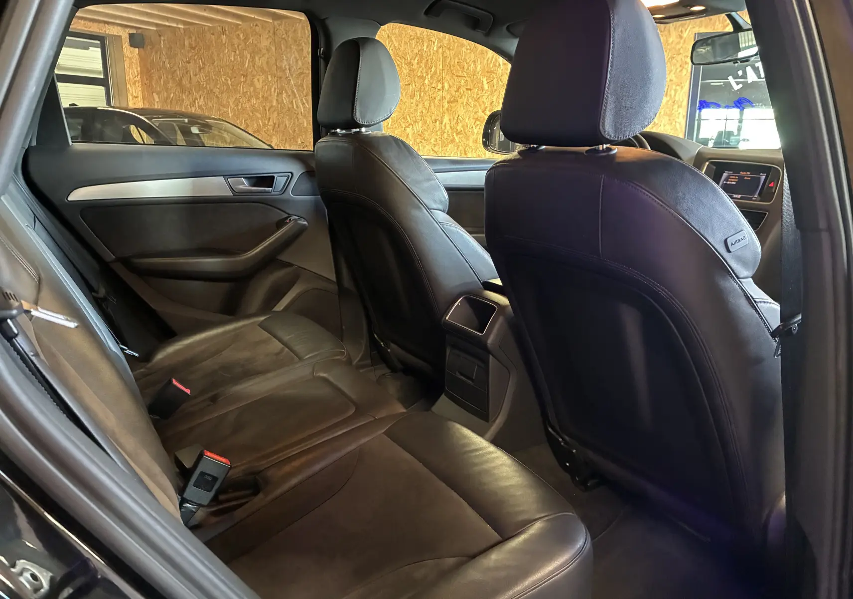 Vue intérieure arrière droite de l'Audi SQ5 noire montrant les sièges sport en cuir et les finitions élégantes.