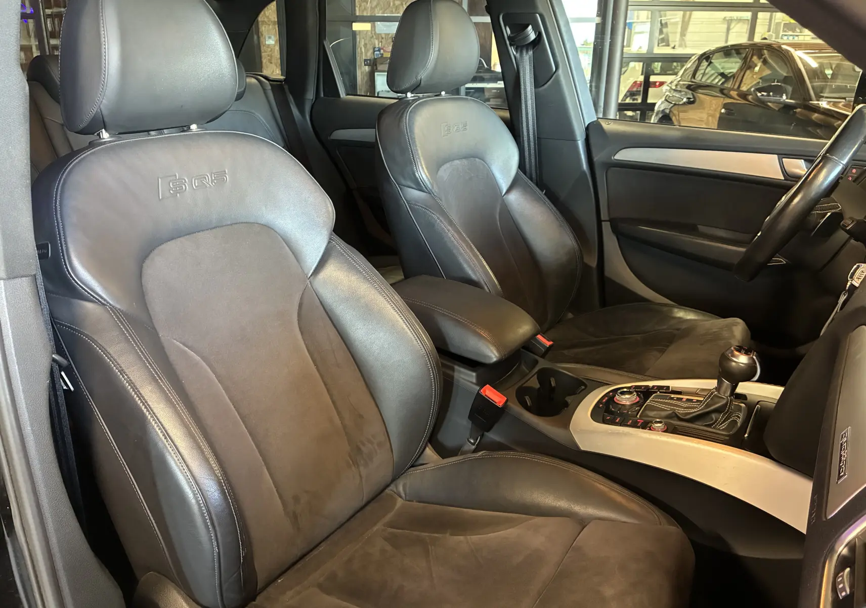 Vue intérieure côté avant droit de l’Audi SQ5 2016 avec sièges sport cuir et alcantara noirs embossés SQ5.