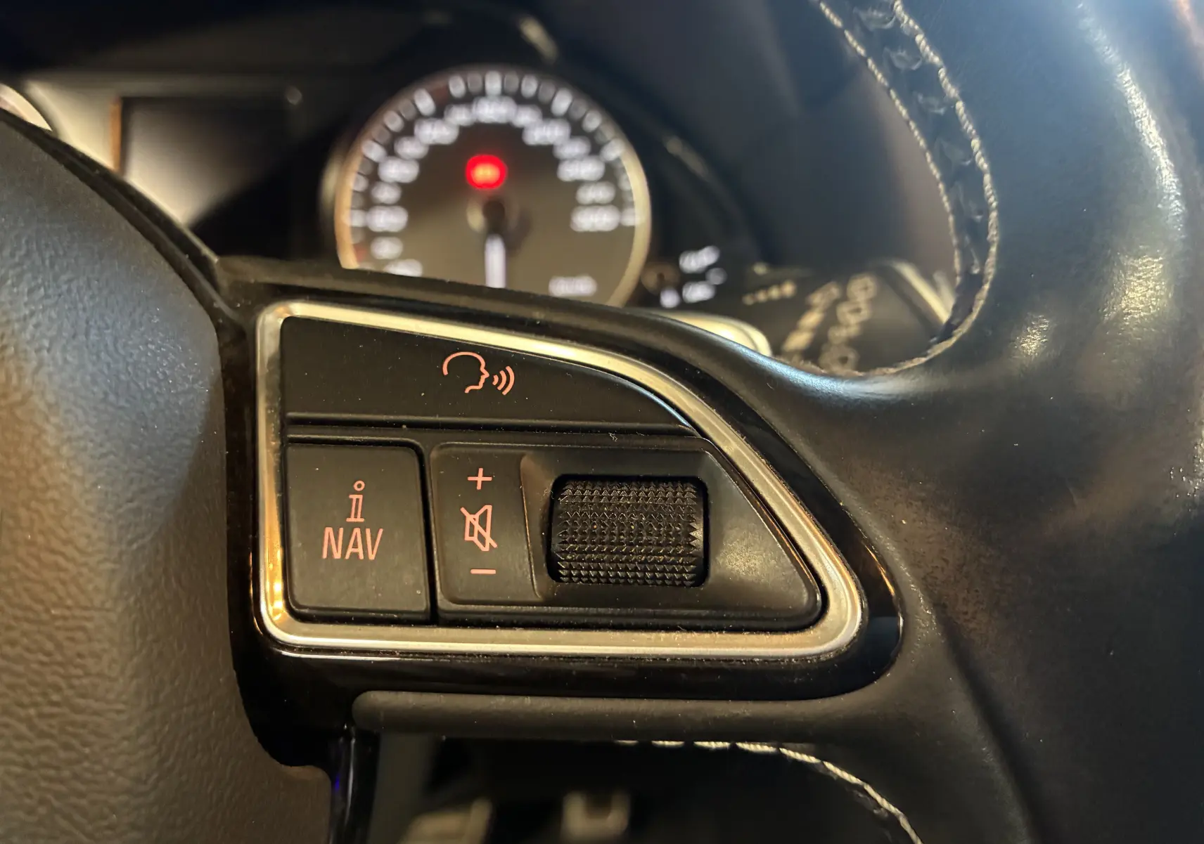 Gros plan sur les commandes vocales et volume sur le volant cuir noir de l'Audi SQ5 2016, avec tableau de bord flou en arrière-plan.