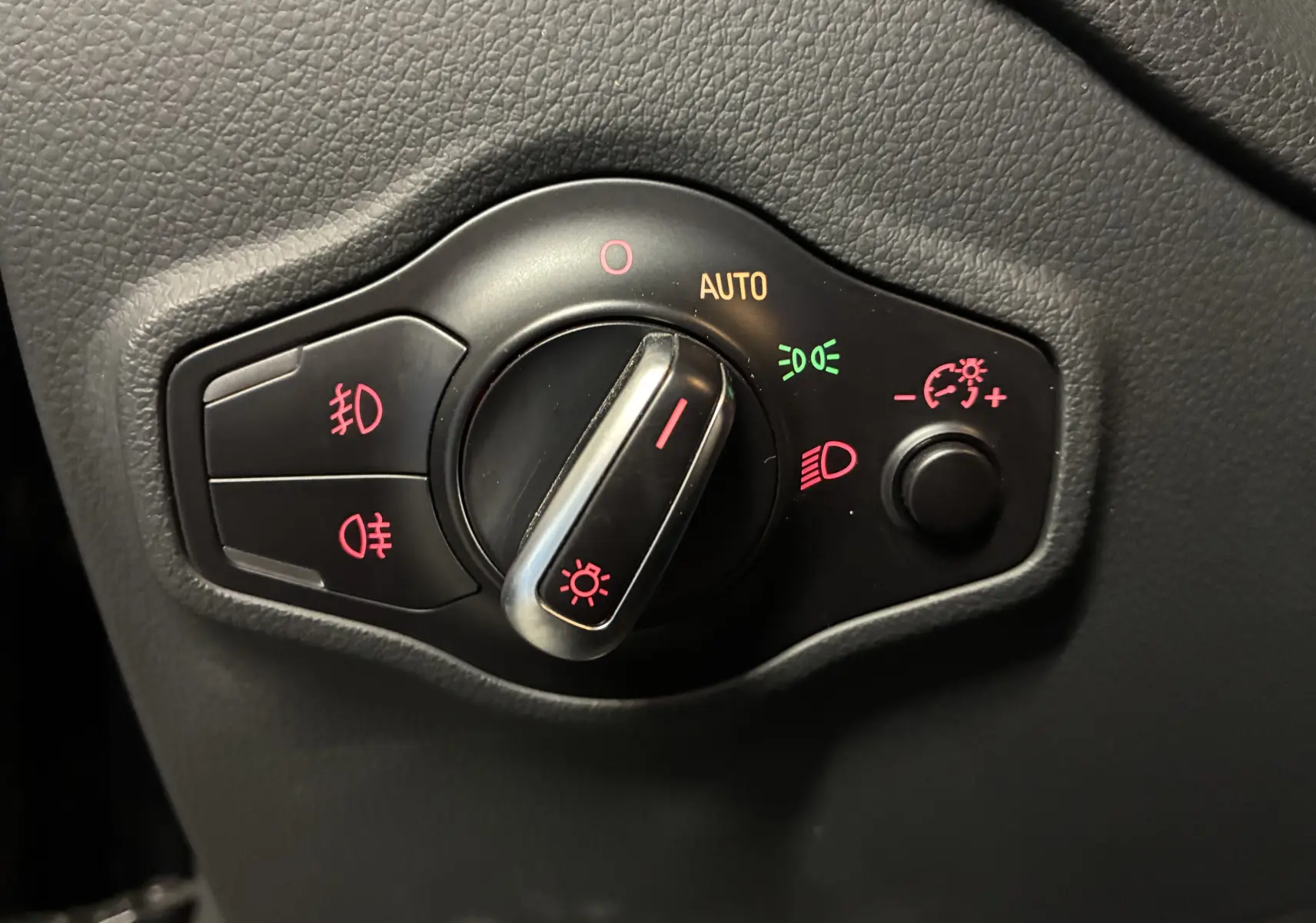 Gros plan sur la commande des phares avec réglages auto et antibrouillard, intérieur noir de l'Audi SQ5 2016.