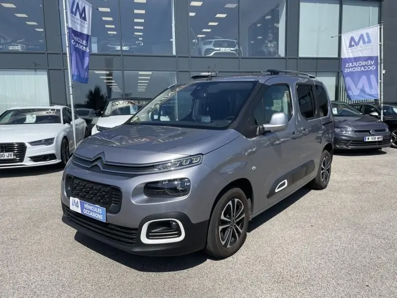 Vue 3/4 avant droite d'un Citroën Berlingo gris métal 2018 avec détails noirs et jantes alliage distinctives.