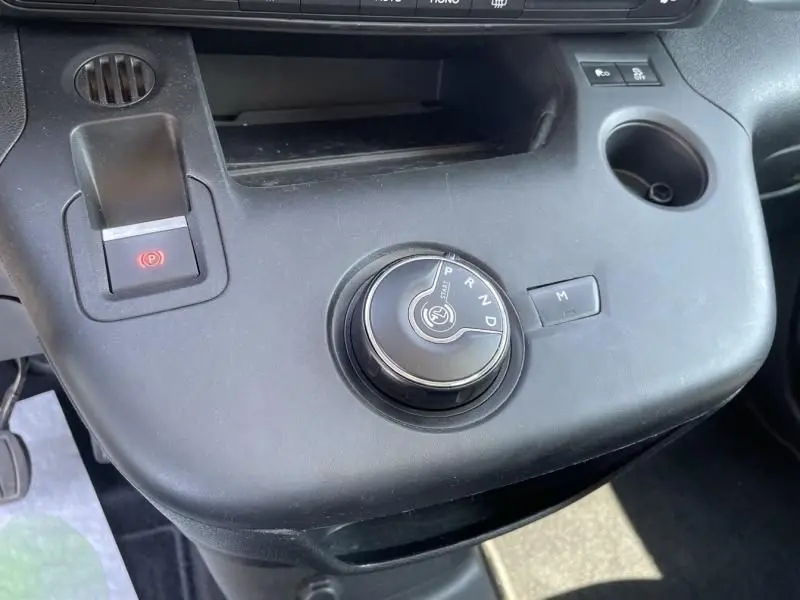 Vue rapprochée de la console centrale du Citroën Berlingo gris métal 2018, avec sélecteur rotatif de boîte auto et frein électrique.