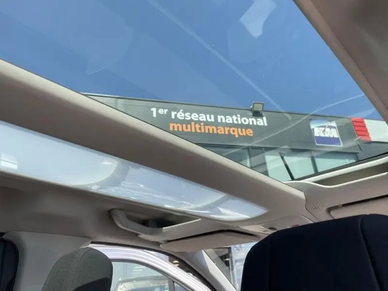 Toit panoramique ouvert sur l'intérieur d'un Citroën Berlingo gris métal 2018, vue depuis l'arrière côté droit.