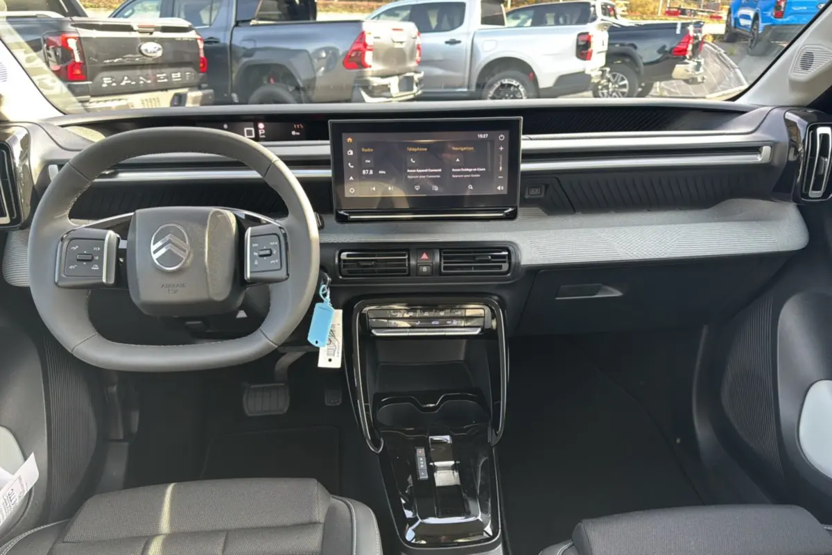Vue intérieure du tableau de bord du Citroën C3 Aircross Hybrid 145, avec écran tactile central et volant multifonctions cuir.