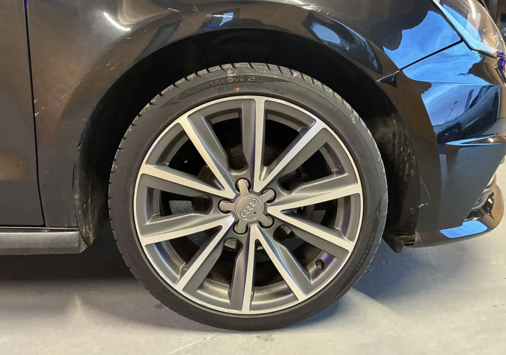 Gros plan sur la roue avant droite d'une Audi A1 noire de 2016 avec jante alliage 17 pouces S-Line.