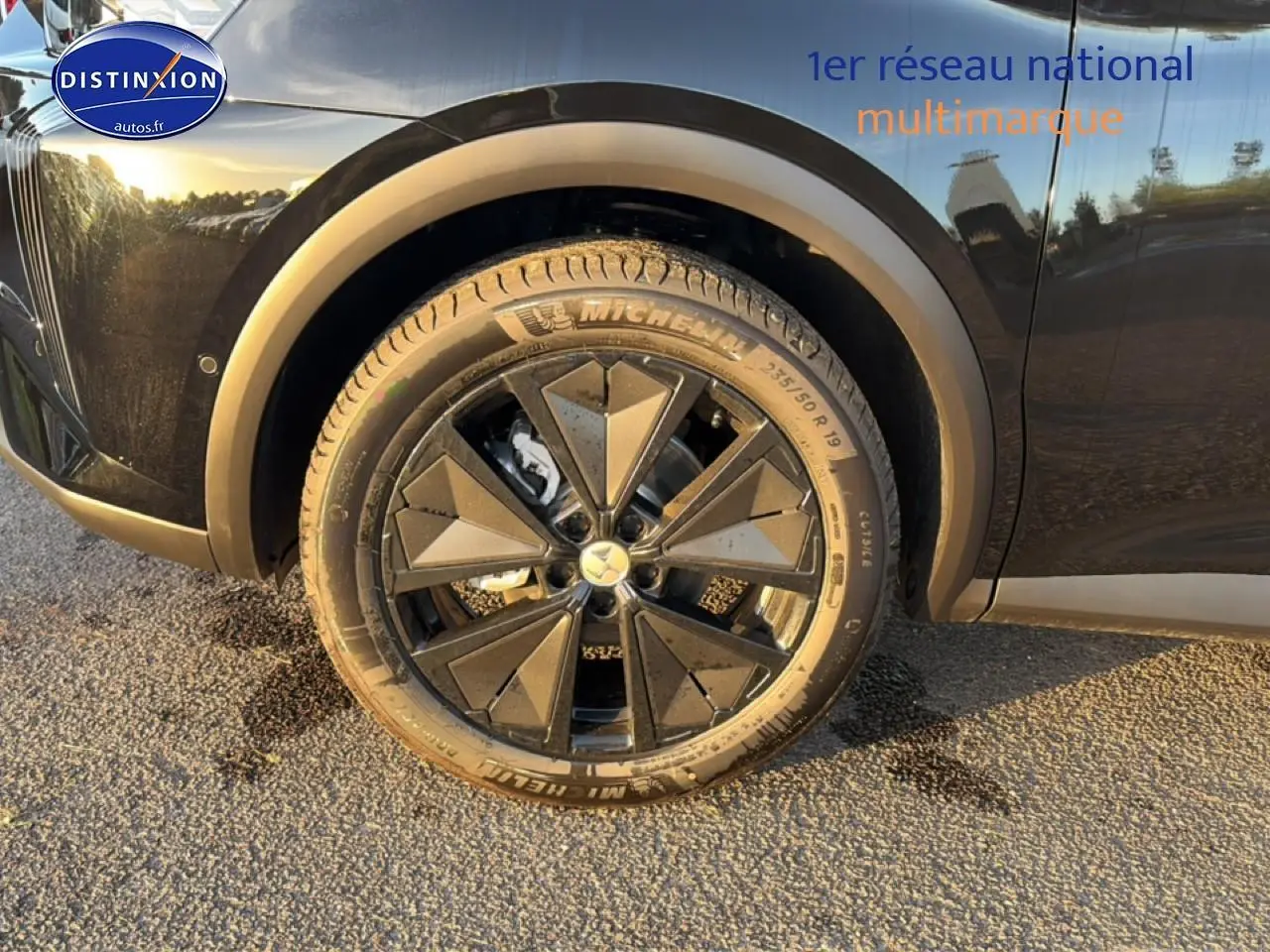 Gros plan sur la roue avant gauche noire avec jante alu au design géométrique du DS7 1.5 BlueHDi 130 Performance Line 2026.