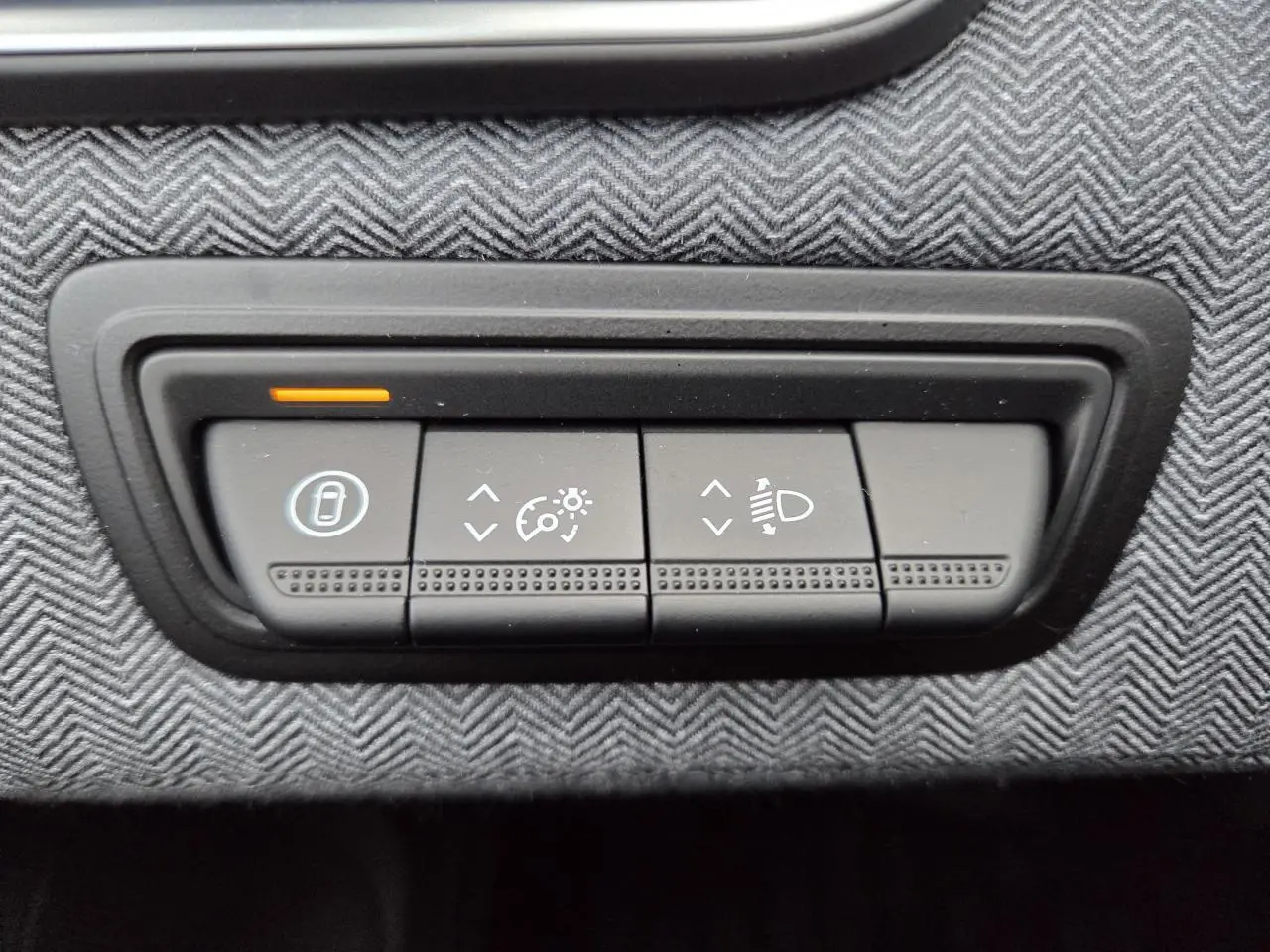 Gros plan sur les commandes d’éclairage et de régulateur de vitesse sur tableau de bord gris texturé d’une Renault Clio 2025.