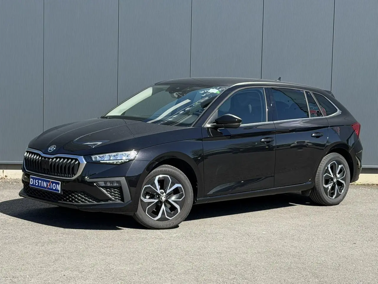 Vue 3/4 avant droite d'une Skoda Scala noir Magic Perle avec jantes alliage et calandre marquée.