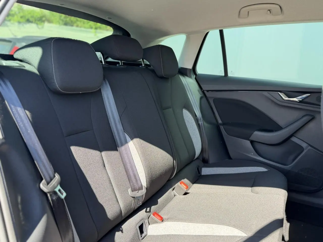 Vue intérieure côté droit des sièges arrière noirs avec ceintures et garnitures grises d'une Skoda Scala 2025.