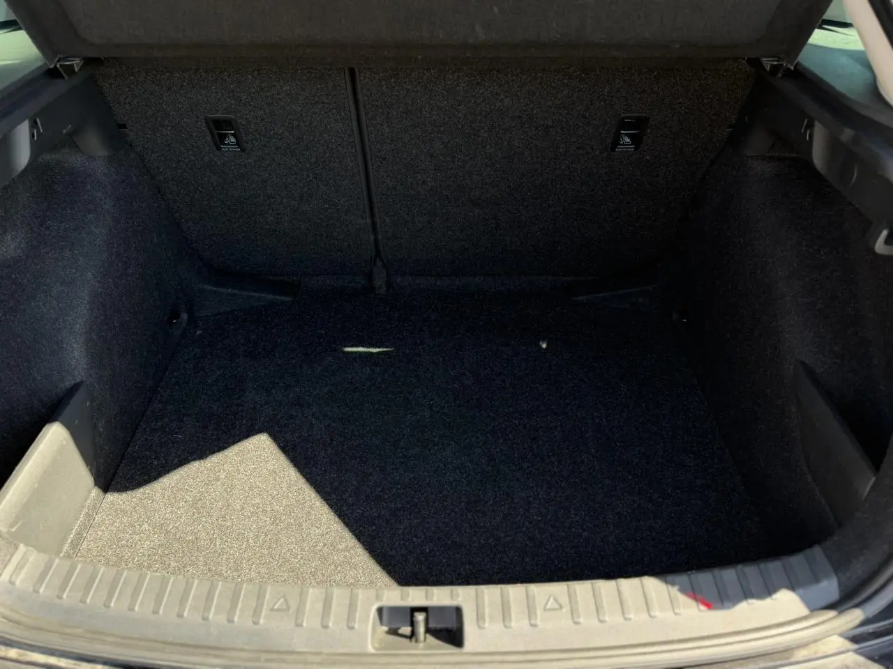 Coffre ouvert de la Skoda Scala TSI 116 DSG7 noir Magic Perle, montrant l'espace de rangement intérieur vide.