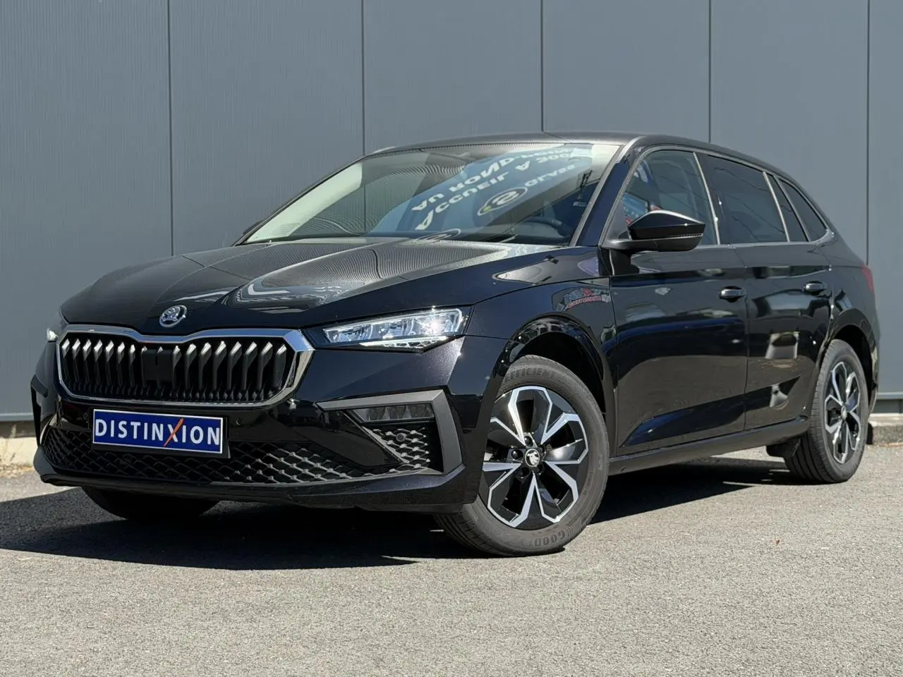 Vue 3/4 avant droite d'une Skoda Scala noire Magic Perle avec jantes alliage et calandre chromée.