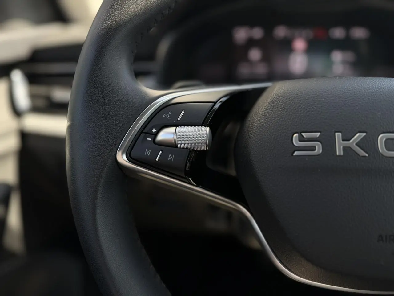 Gros plan sur les commandes gauche du volant cuir noir du Skoda Scala TSI 116 DSG7 Sélection 2025.