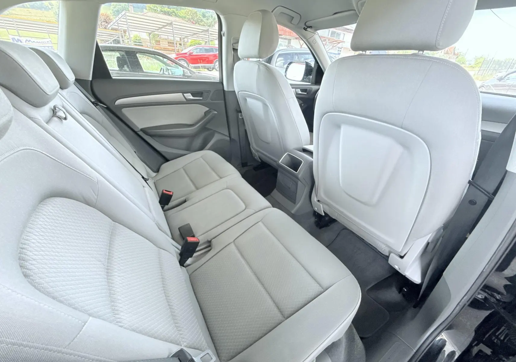 Vue intérieure arrière côté droit montrant les sièges en tissu clair de l'Audi Q5 noir de 2014.