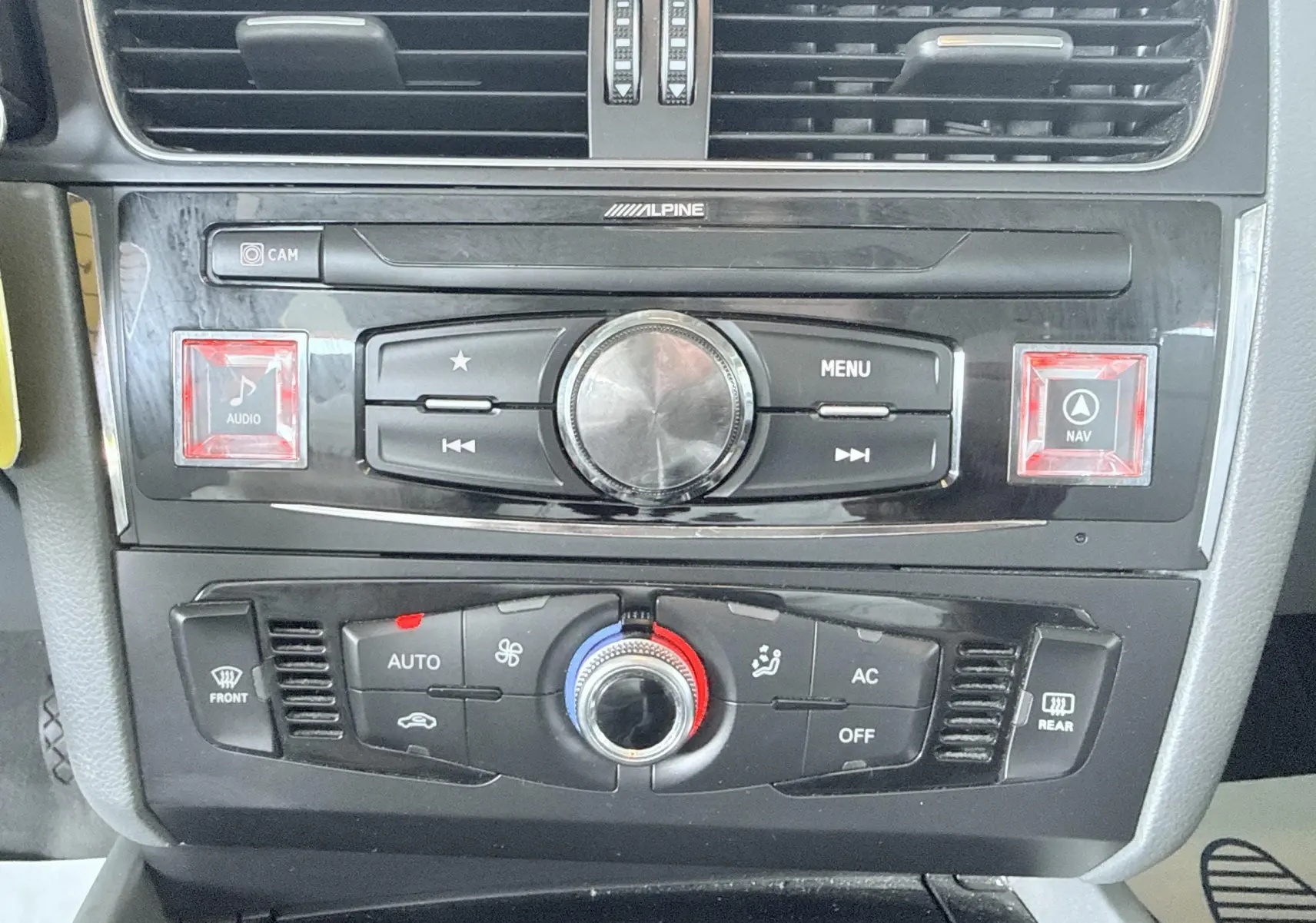 Vue rapprochée de la console centrale noire de l'Audi Q5 2014, avec commandes audio Alpine et climatisation automatique.