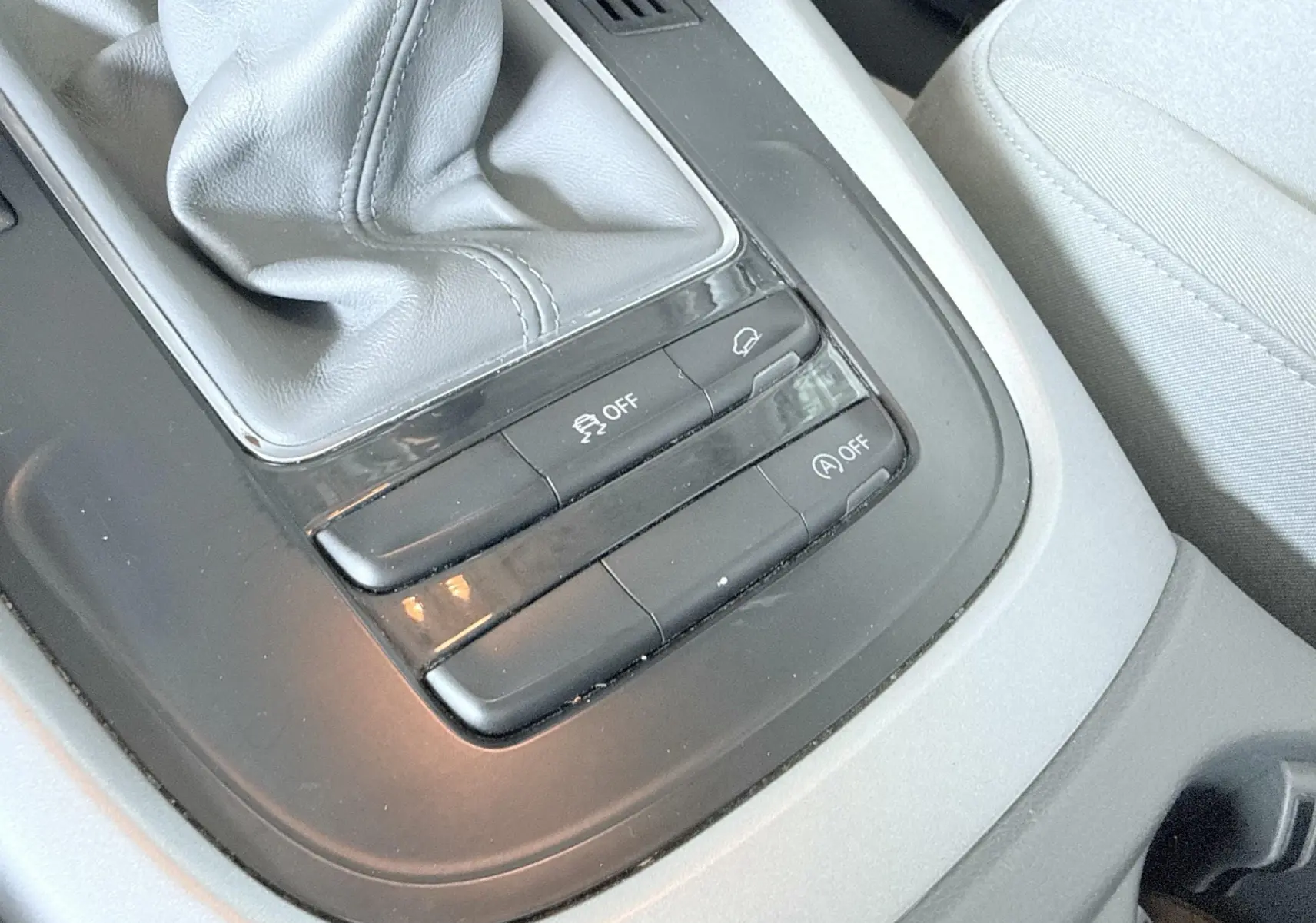Gros plan sur la console centrale grise avec levier de vitesse manuel et boutons de contrôle dans un Audi Q5 noir.