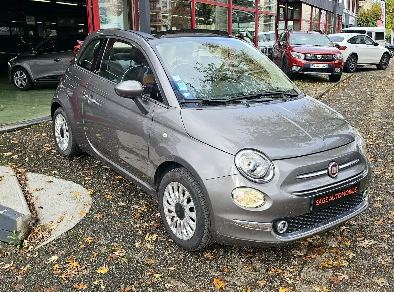 Intérieur avant de la Fiat 500C grise, tableau de bord avec volant, commandes manuelles et écran central tactile.