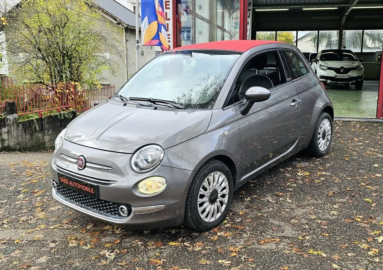 Vue frontale d'une FIAT 500C grise Electroclash avec toit rouge, sur fond neutre en extérieur.