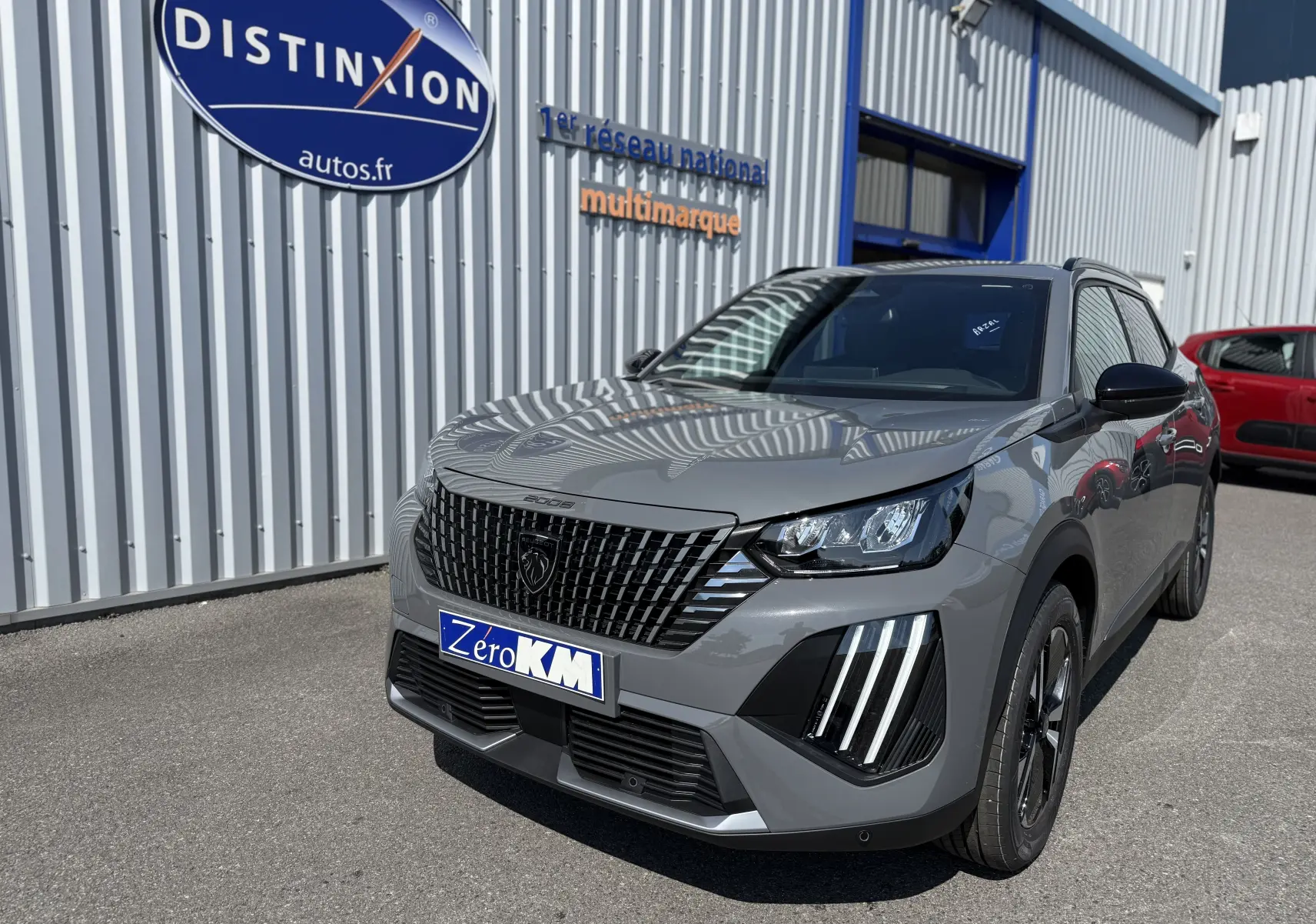 Peugeot 2008 Hybrid 145ch gris selenium en 3/4 avant droit, avec calandre noire distinctive et feux LED verticaux.