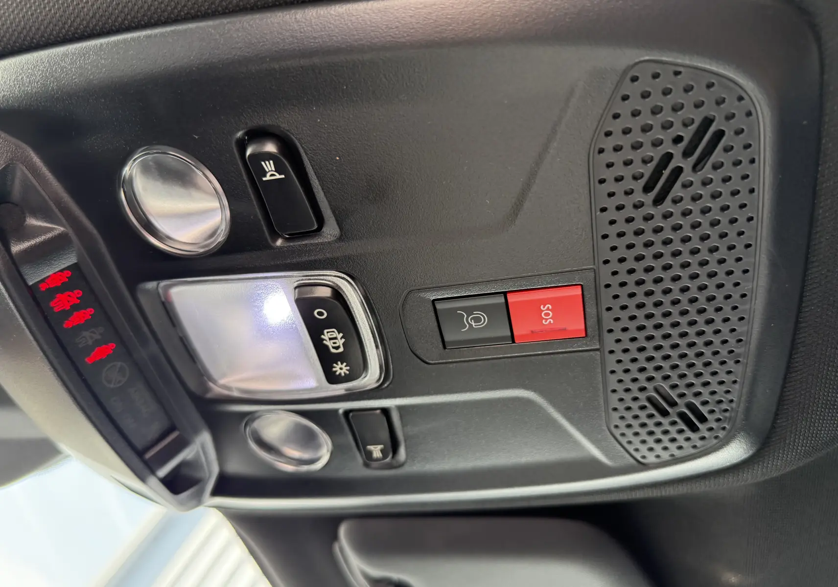 Panneau de commandes au plafond intérieur du Peugeot 2008 Hybrid gris, avec bouton SOS rouge et éclairage intégré.