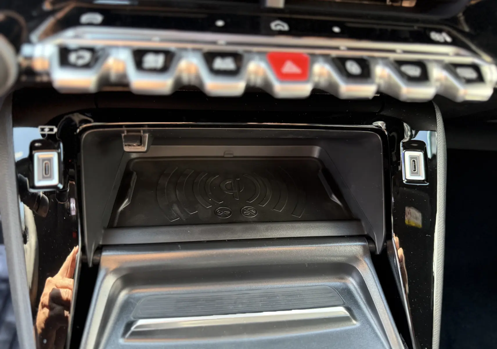 Gros plan sur la console centrale du Peugeot 2008 gris Selenium 2025, montrant le chargeur à induction et les ports USB.