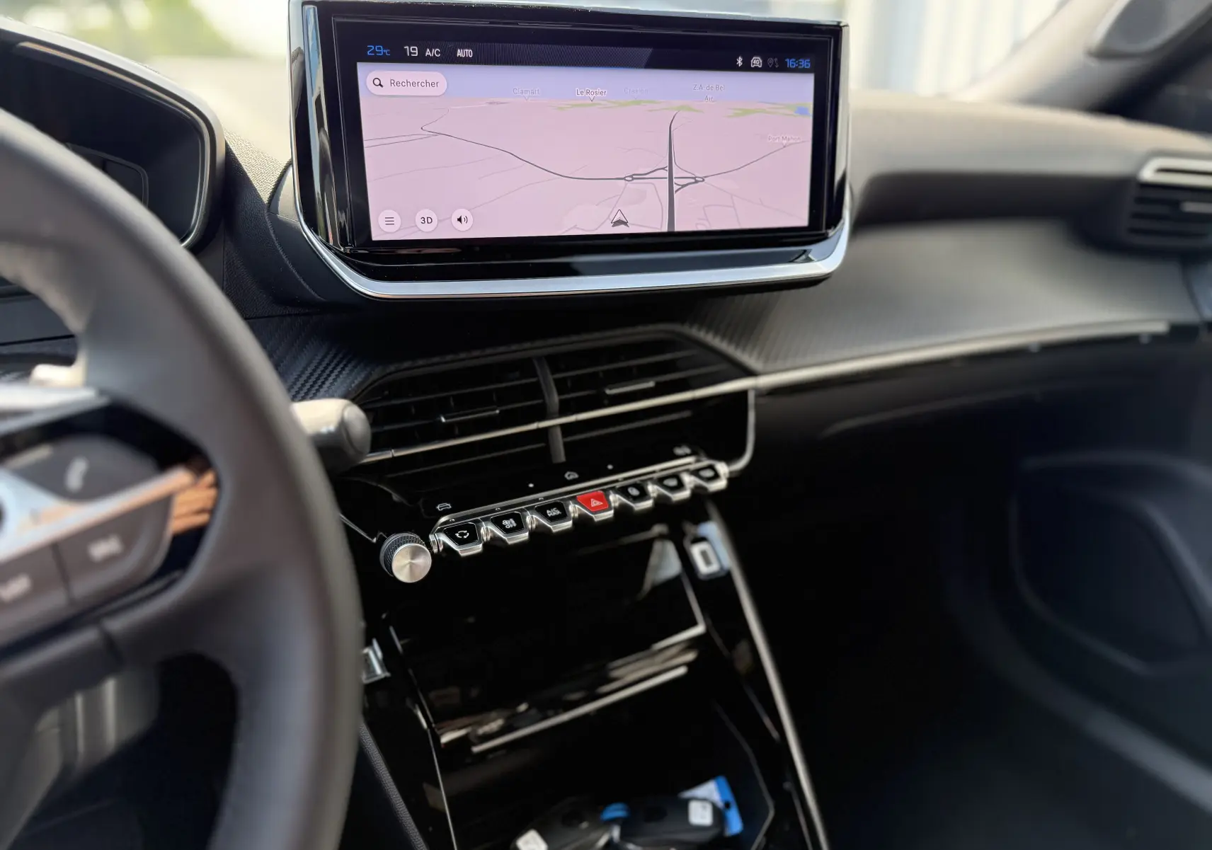 Vue intérieure du tableau de bord du Peugeot 2008 Hybrid 145ch Allure 2025, avec écran tactile affichant la navigation et commandes piano noires.