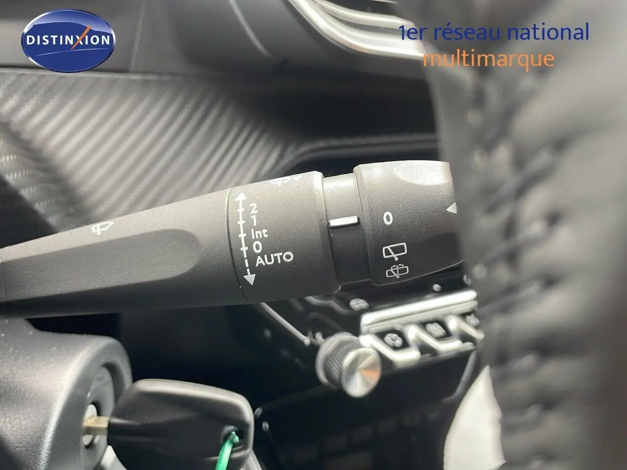 Gros plan sur la commande d'essuie-glace à gauche du volant dans l'habitacle du Peugeot 2008 bleu Vertigo Metal 2024.