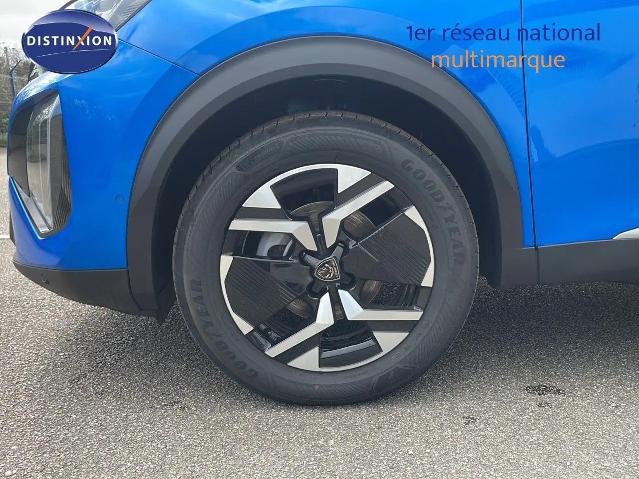 Gros plan sur la roue avant gauche d'un Peugeot 2008 bleu Vertigo Metal avec jante noire et argentée.
