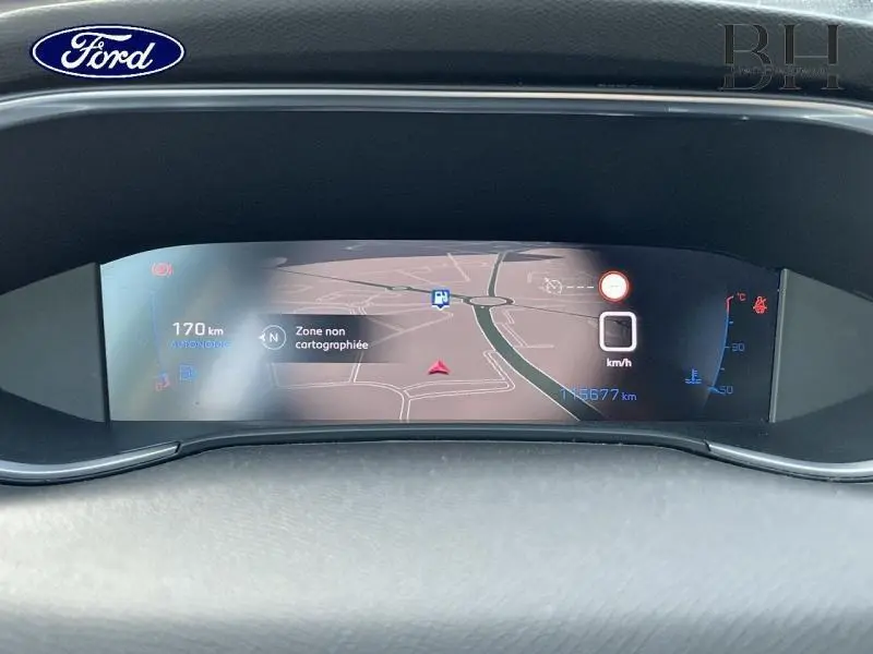 Tableau de bord numérique avec navigation affichée, compteur et jauges dans un Ford, vue frontale rapprochée.