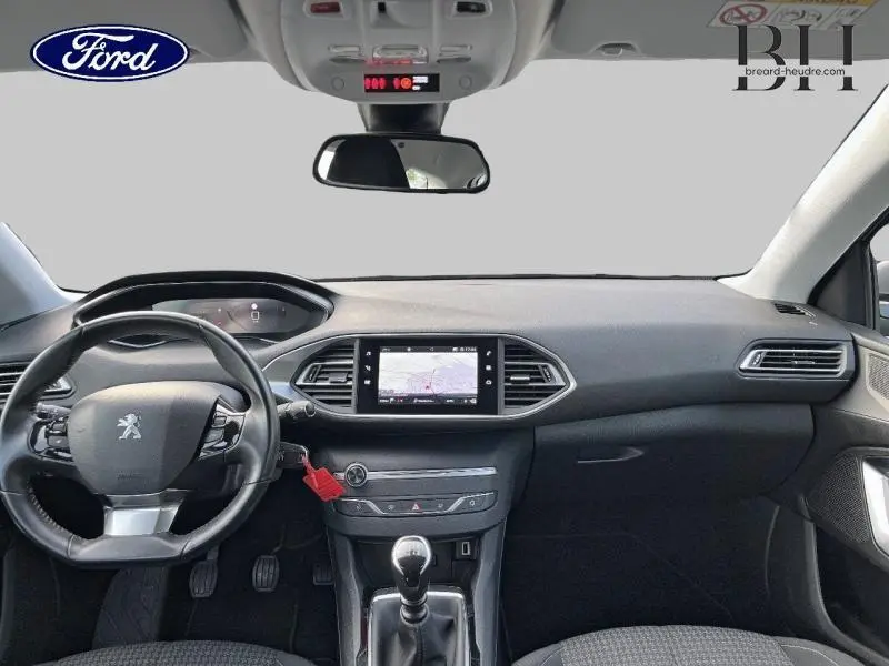 Intérieur de la Peugeot 308 SW 2021 en gris, vue frontale du tableau de bord avec écran tactile et volant multifonction cuir.
