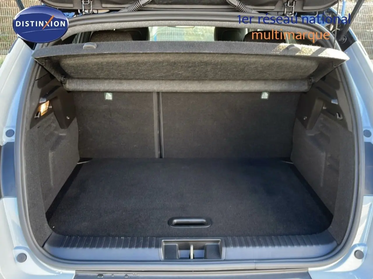 Coffre ouvert d’un Renault Captur gris Rafale métal avec intérieur noir, vue arrière montrant l’espace de chargement.