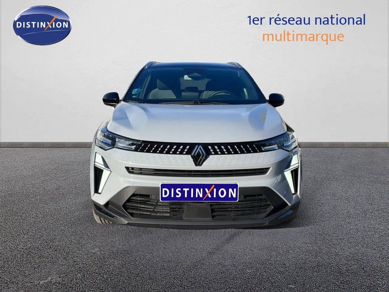 Vue avant d'un Renault Captur 2025 gris Rafale métal avec toit noir, mettant en valeur sa calandre moderne et ses phares LED.