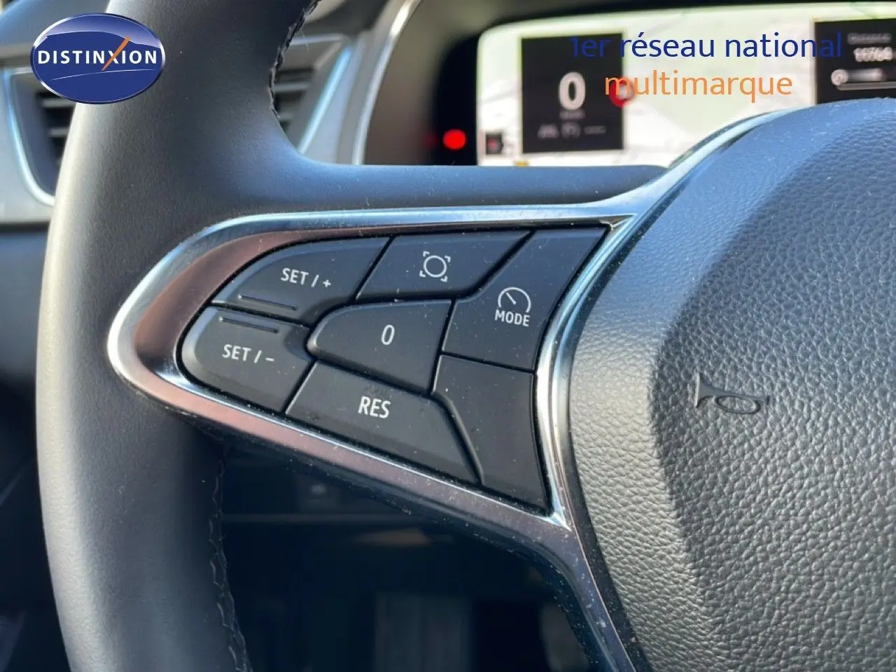 Gros plan sur les commandes au volant côté gauche du Renault Captur gris Rafale 2025 avec tableau de bord numérique visible.