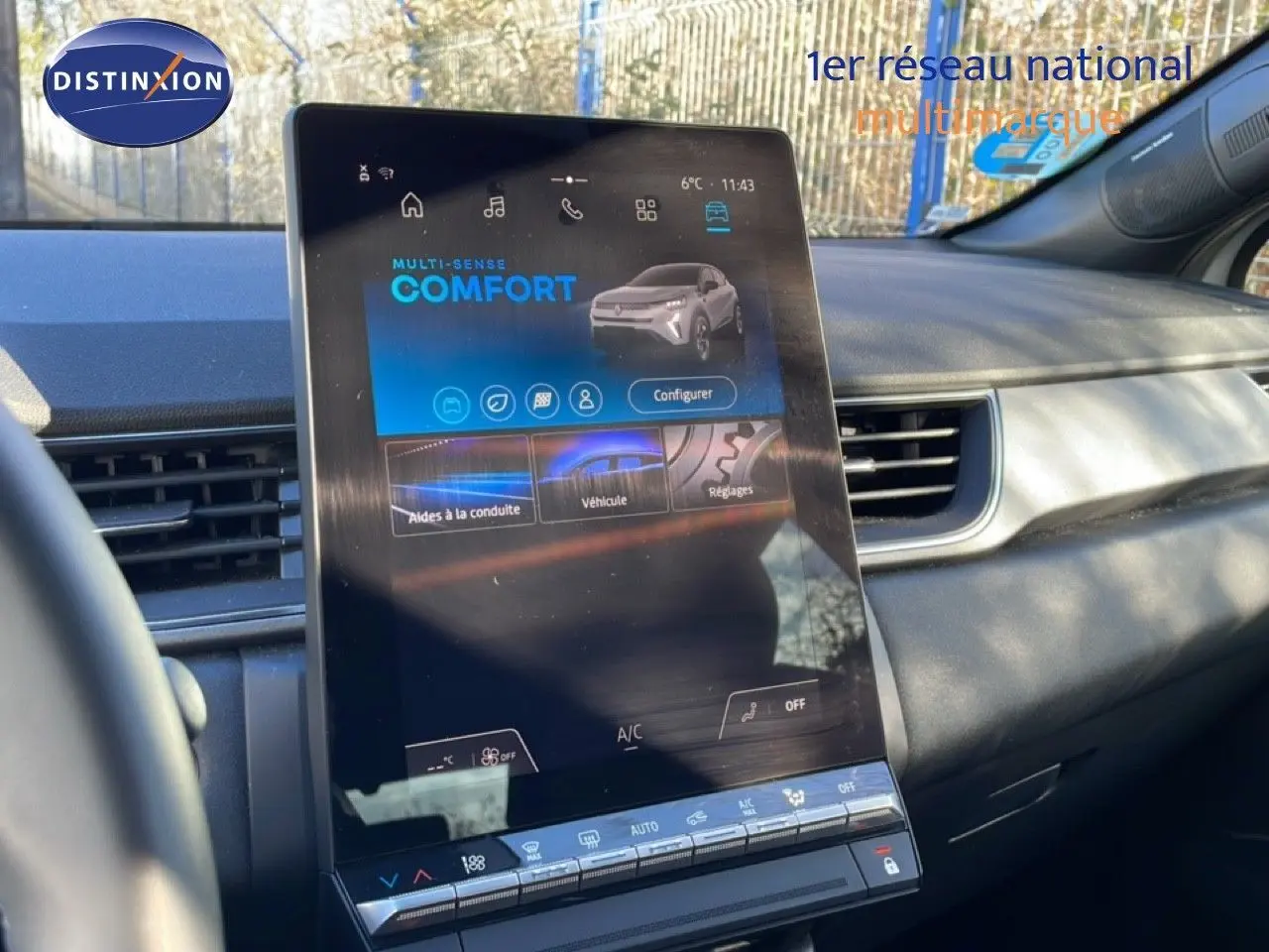 Vue intérieure centrée sur l'écran tactile vertical du tableau de bord du Renault Captur gris Rafale métal.