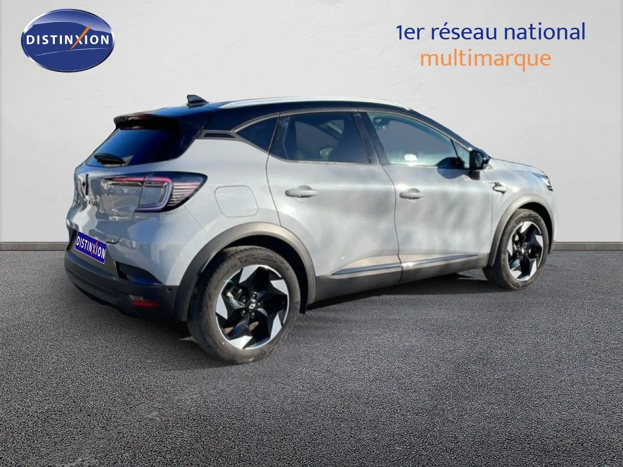 Vue 3/4 arrière droite d'un Renault Captur gris Rafale métallisé avec toit noir et jantes bicolores.