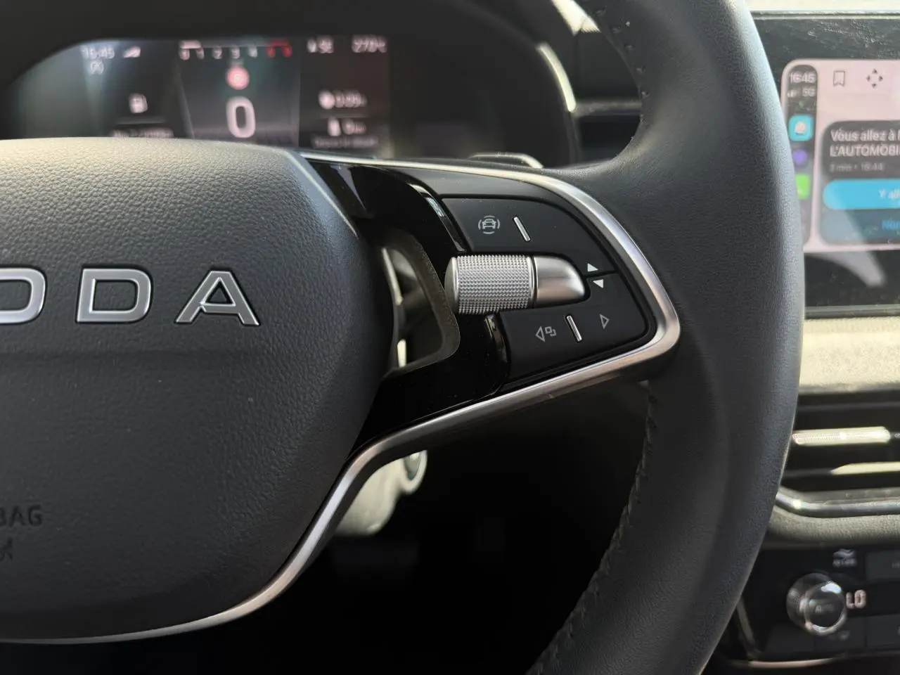 Gros plan sur le volant cuir noir côté droit du Skoda Scala 2025 avec commandes multifonctions et tableau de bord numérique.