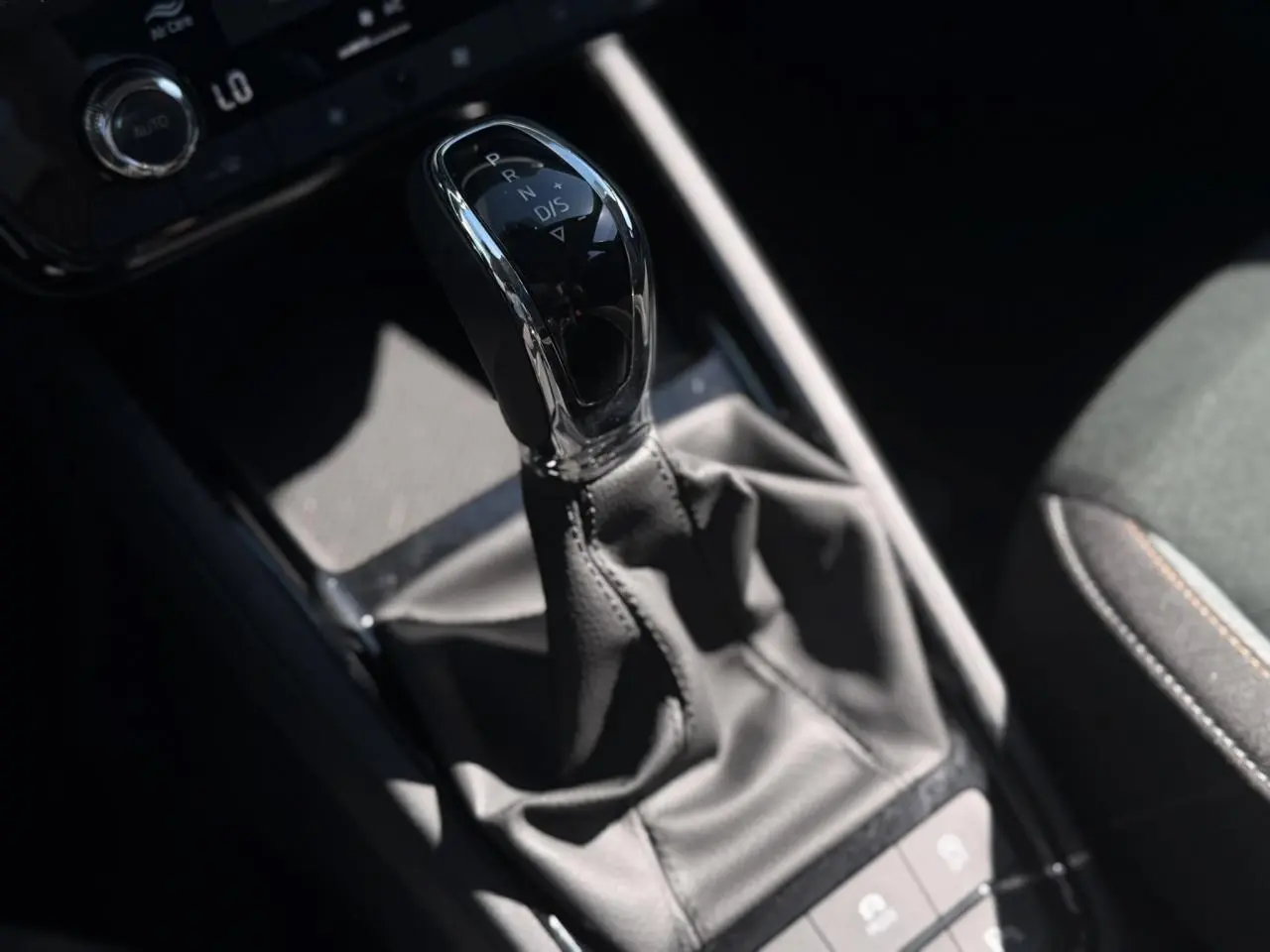 Le levier de vitesse automatique noir et chrome de la Skoda Scala TSI 116 DSG7 Sélection en gros plan intérieur.