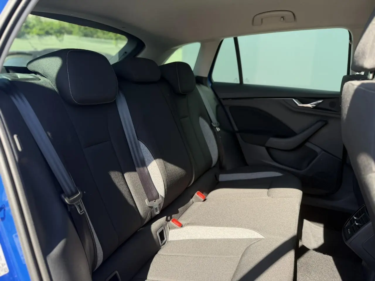 Vue intérieure côté droit des sièges arrière en tissu gris et noir du Skoda Scala Bleu Energy 2025.
