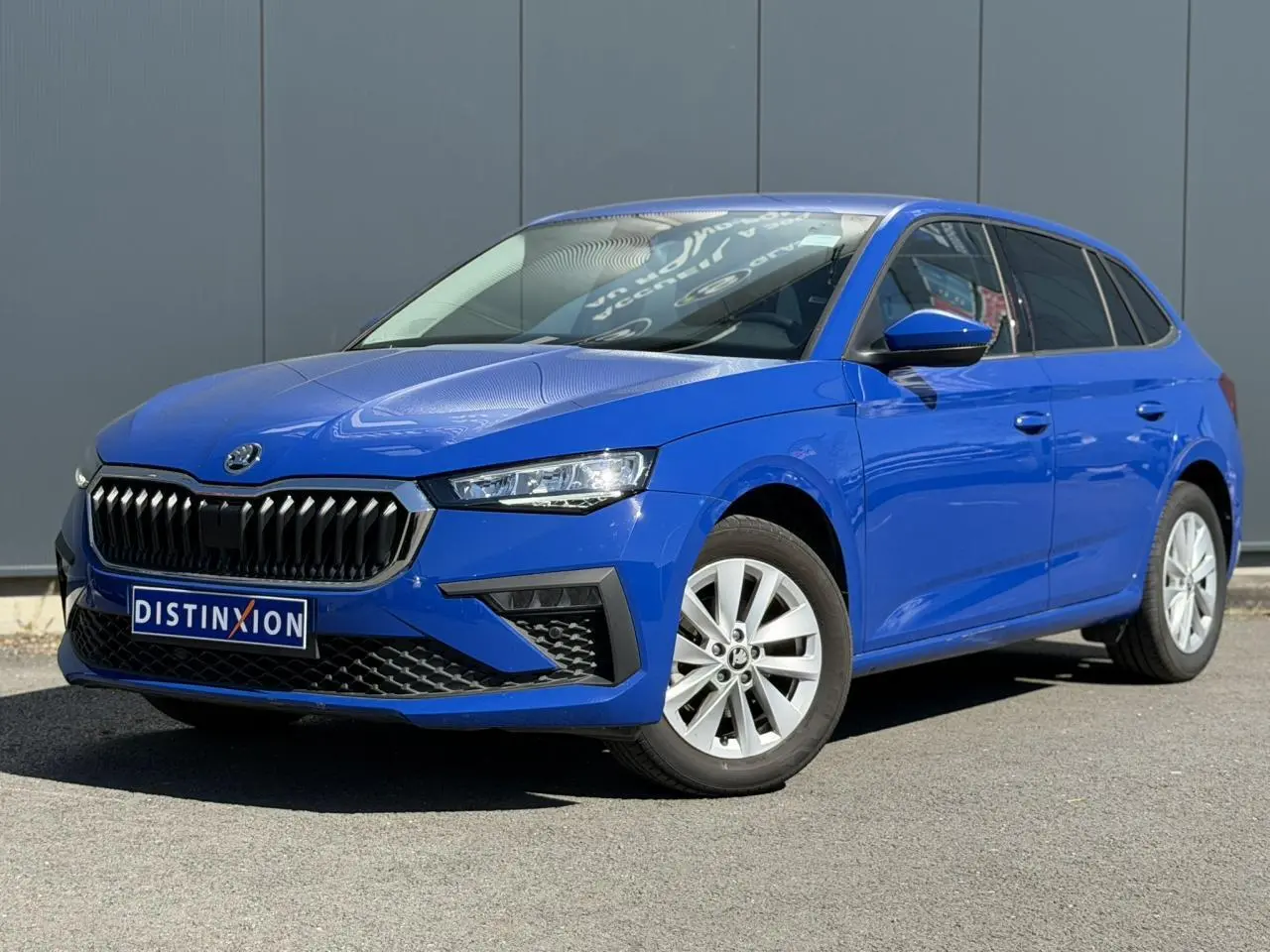 Vue 3/4 avant droite d'une Skoda Scala bleu Energy avec calandre noire et jantes alliage 16 pouces.