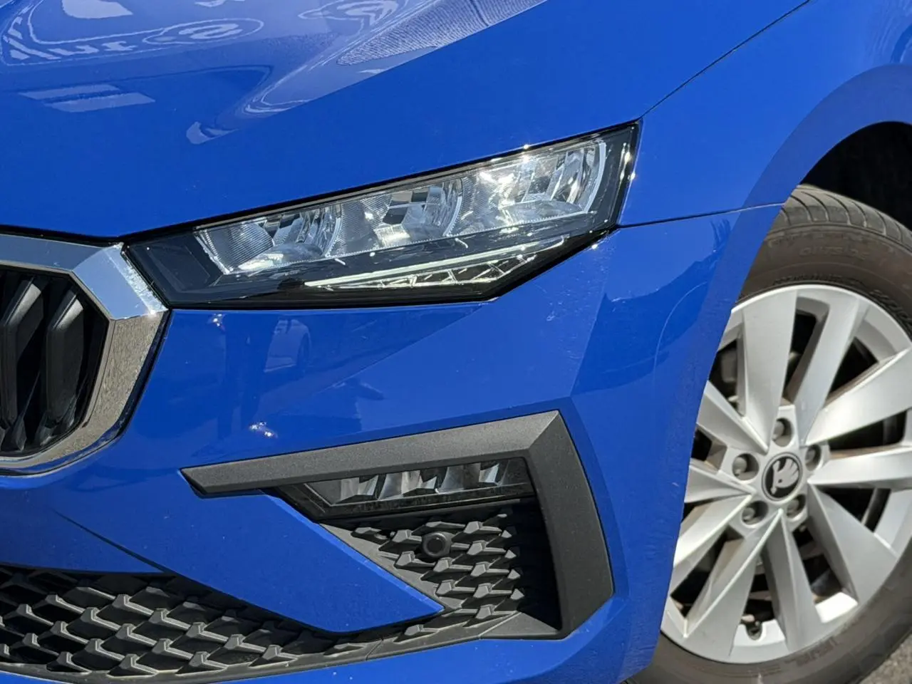 Gros plan sur l'avant droit de la Skoda Scala bleu Energy, mettant en valeur le phare LED et la jante alliage 16 pouces.