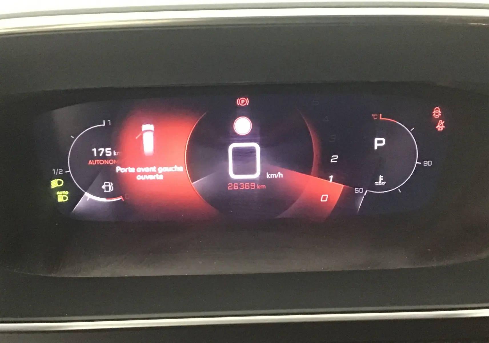 Tableau de bord numérique du Peugeot 2008 blanc nacré, affichant porte avant gauche ouverte et compteur kilométrique.