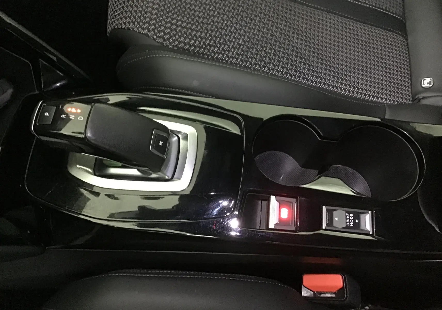 Vue rapprochée de la console centrale noire brillante du Peugeot 2008 GT 2021 avec levier de vitesse automatique et porte-gobelets.