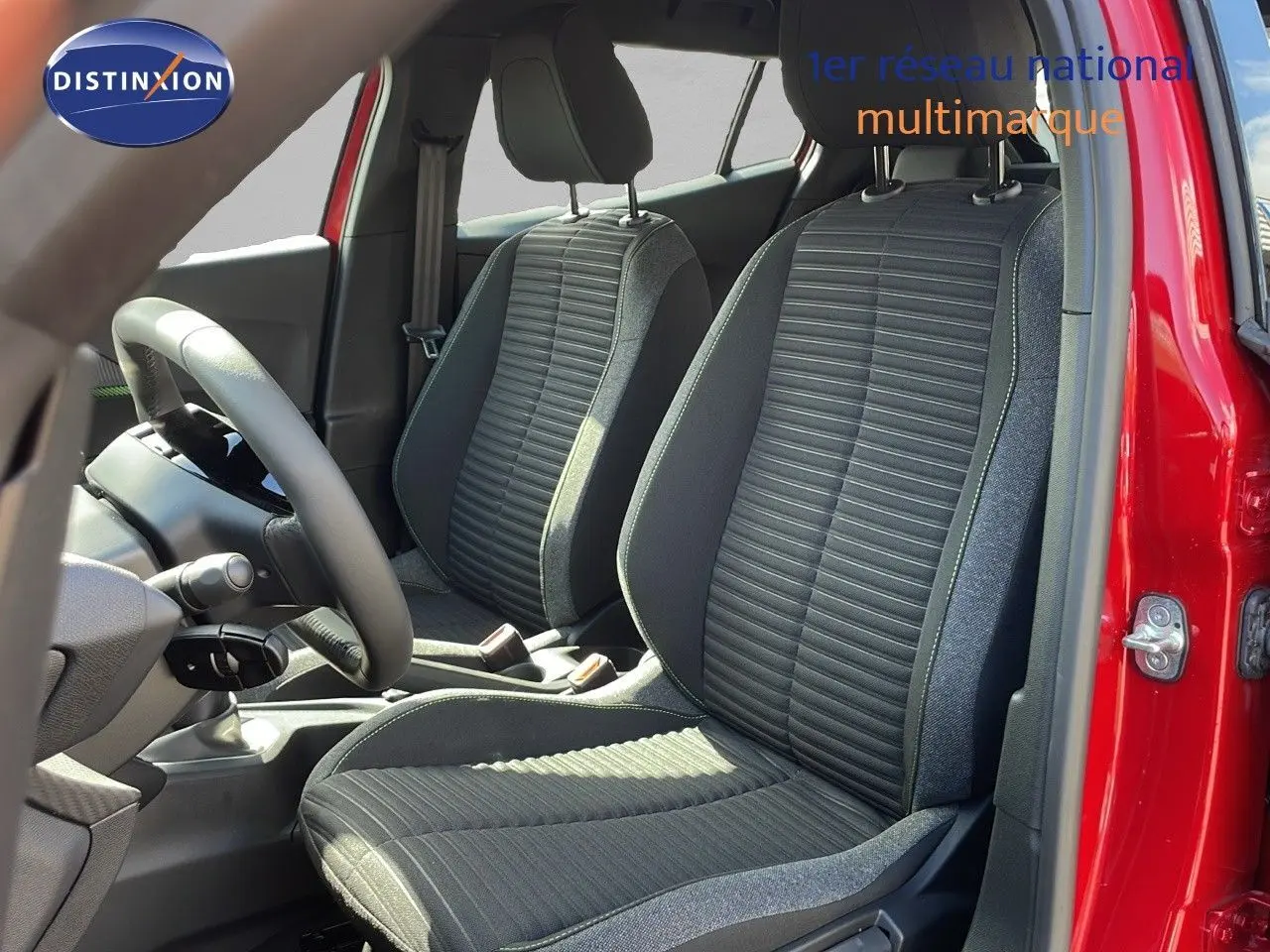 Intérieur de la Peugeot 2008 2025 rouge Elixir, vue des sièges avant en tissu noir et gris côté conducteur.