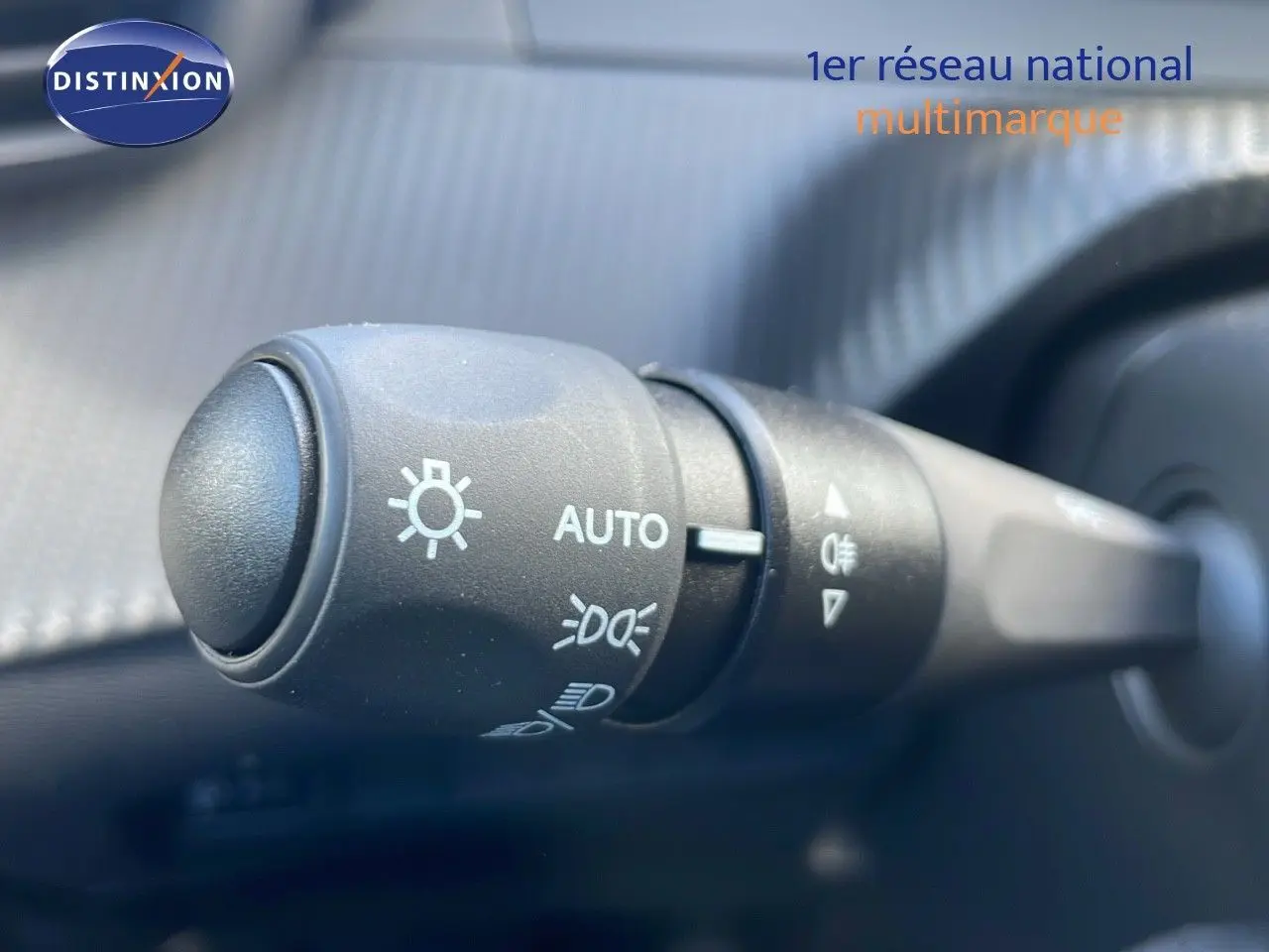 Gros plan sur la commande des phares du Peugeot 2008 2025, version essence rouge Elixir Metal, intérieur noir.