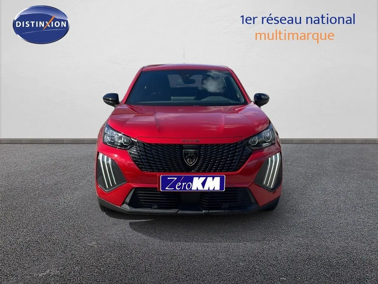 Vue frontale d'un Peugeot 2008 rouge Elixir Metal avec calandre noire et feux LED distinctifs allumés.