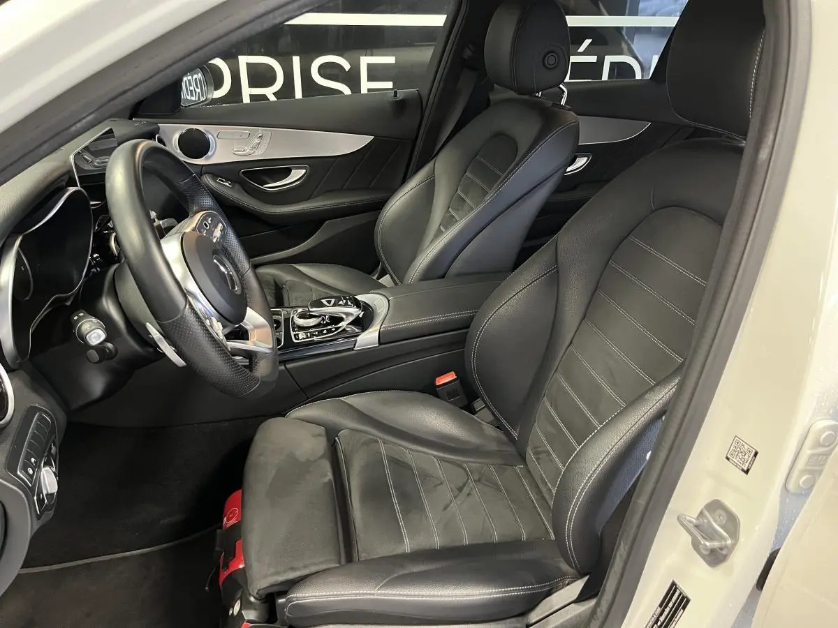 Intérieur noir cuir AMG de la Mercedes Classe C Break C 300 e vu côté conducteur avec volant multifonction et console centrale.