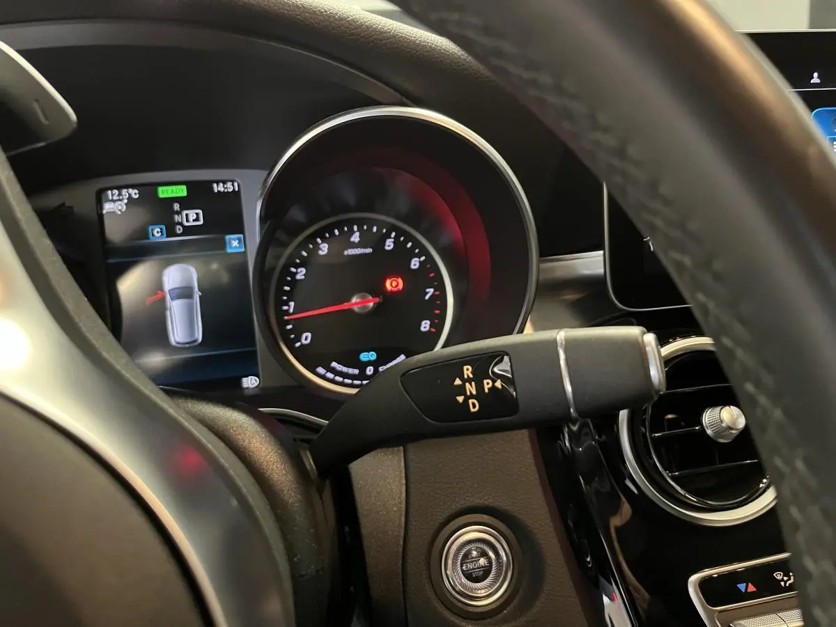 Gros plan intérieur sur le tableau de bord et levier de vitesses de la Mercedes Classe C Break blanc hybride 2019.